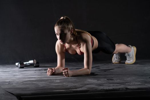 Plank with the dumbbells on in girl a stands the floor push-ups looks like a kira knightley girl plank black, In the afternoon caucasian fit from woman from sport athlete, strong biceps.