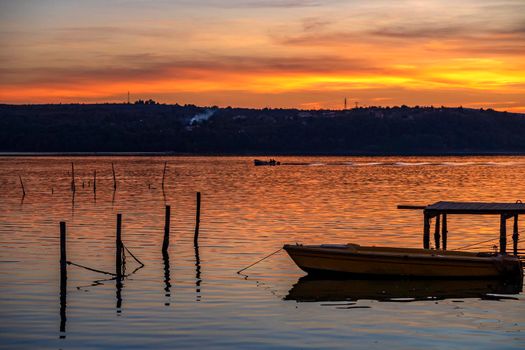 Moored wooden boat at the wooden pier after sunset 