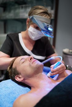 Shot of a man getting a non-invasive face lift at a beauty clinic.