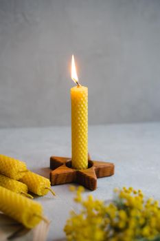 Set of honey candles. Wooden candle stand. Wooden candle holder in the form of an asterisk. A natural product. Vertical photo.