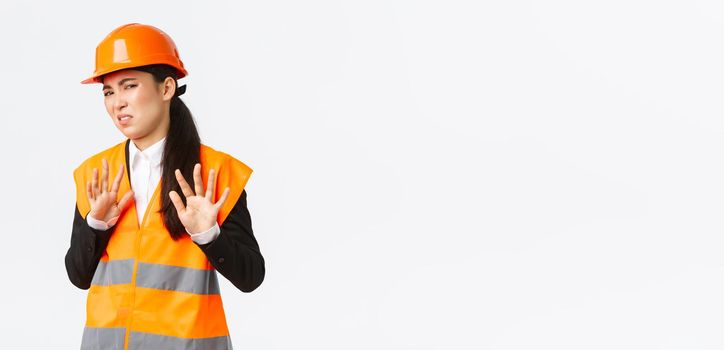 Reluctant and displeased asian female engineer refuse listen, showing stop, prohibit gesture, rejecting bothering offer, annoyed with clingy project manager, white background.