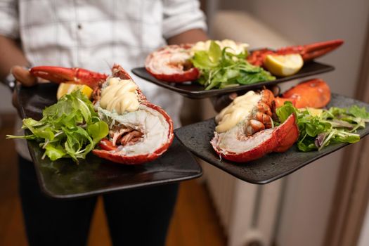 Waiter holding lobsters with mayonnaise