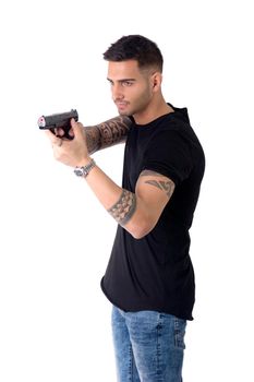 Young handsome man pointing gun, wearing black t-shirt, isolated on white background