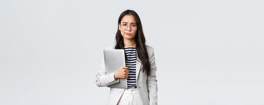 Business, finance and employment, female successful entrepreneurs concept. Sad and doubtful businesswoman having hesitations about meeting, smirk displeased, holding laptop.