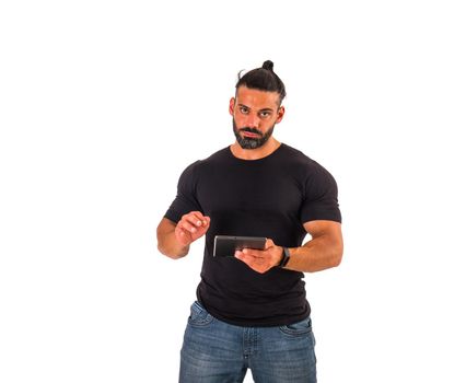 Attractive muscular man using electronic tablet, tapping on it, standing in studio shot isolated on white