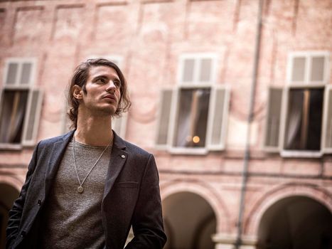 Elegant attractive young man outdoor wearing wool coat, in European city