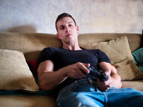 Good looking young man holding joystick, gamepad or joypadplaying video game
