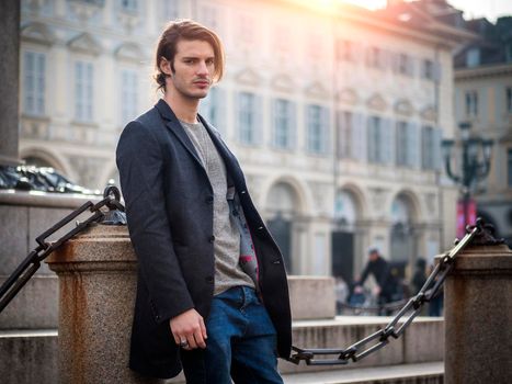 Elegant attractive young man outdoor wearing wool coat, in European city