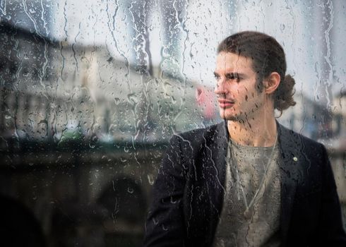 Elegant attractive young man outdoor wearing wool coat, in European city