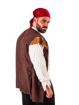Muscular male pirate in studio shot, wearing bandana and open vest, looking at camera