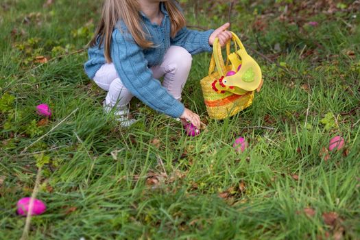 Girl collects the eggs in a basket Easter