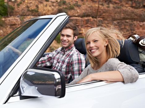 Shot of a young couple enjoying a drive in a convertible.