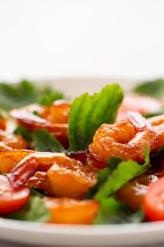 Close-up of fresh shrimp, tomato, arugula and greens salad, vertical image with copy space.