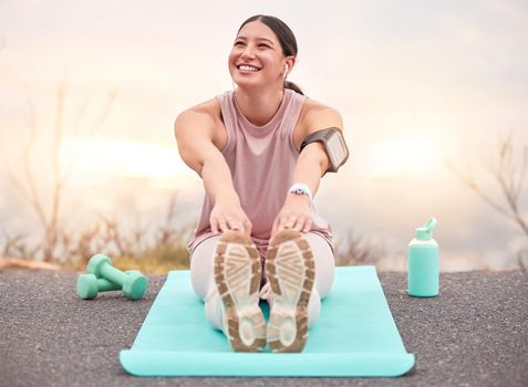 Shot of a young female athlete stretching before a run in nature.