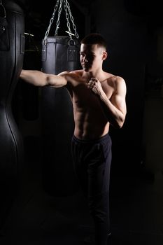 Boxer The the blows athlete bag practices glove black young background boxing, In the afternoon strength muscle from sport and fit hit, studio sweat. Person victory dark, sexy