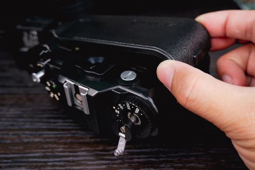 The back cover of the vintage film camera is opened by technical hand