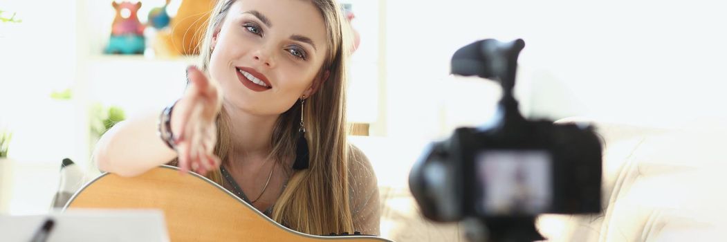 Portrait of pretty young woman record guitar play on videocamera. Becoming famous blogger, start online career, develop music taste, practice in music. Art, social media, content, music concept