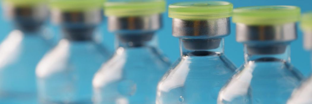 Close-up of glass vials with liquid samples in laboratory, vaccine in bottles, medicine in ampoules. Medication against bacteria and viruses, antibiotics. Stop covid, medicine, healthcare concept