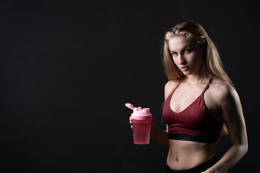 In her pink holds hand spotrsman shaker girl a in black background shaker pink fitness workout, for gym lifestyle from person from training isolated, sexy people. Care model aerobics empty space