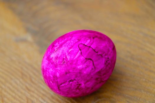 A pink painted egg is on the table. Preparing for Easter