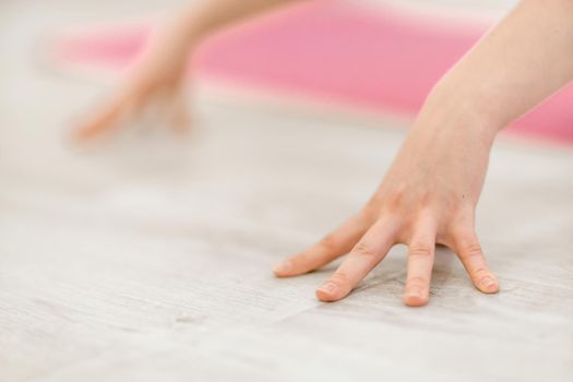 Girl does yoga. Young woman practices asanas on a beige one-ton background