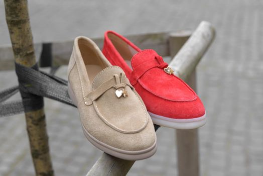 Woman's red and coral stylish suede loafer shoes. Pair of trendy female loafers shoes, outdoors