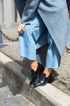 Women's leather boots close-up. The girl walks in black shiny oxford style shoes.