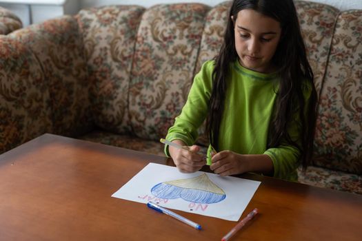 Ukrainian flag and a heart in yellow and blue color. Child draws a heart on the blackboard.