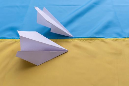 paper airplane on the background flag of Ukraine, flags of the country, blue, yellow.