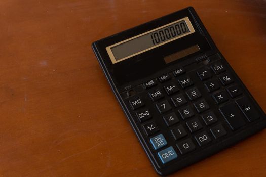 The Old calculator on wooden table.