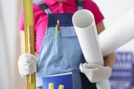 Close-up of person worker holding paper, ruler and pencil. Time to create plan for construction project, make corrections, creative idea, new layout. Foreman, renovation, project concept