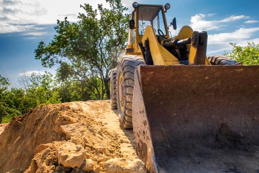 Close up of a big bucket of a yellow excavator 