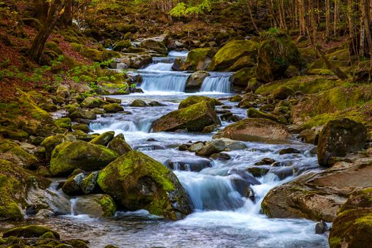 Beautiful autumn landscape of flowing cascade water in a mountain river 