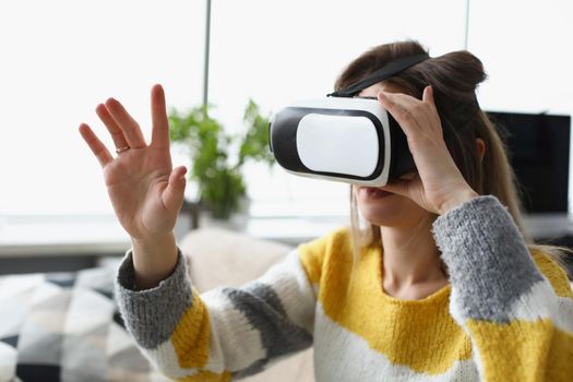 Close-up of young woman experiencing vr modern device at home. Dive into visual effects, fun pastime, adventure time. Modern technology, innovation, entertainment concept