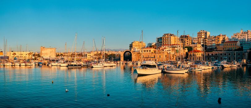 Venetian Fort castle in Heraklion and moored fishing boats, Crete Island, Greece on sunset