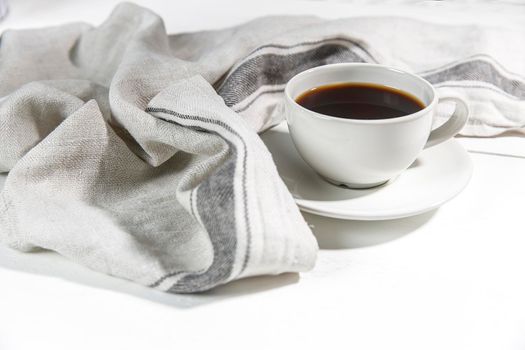 Cup of tea with napkin on white background