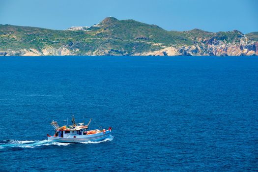 Greek fishing boat in blue waters of Aegean sea near Milos island, Greece