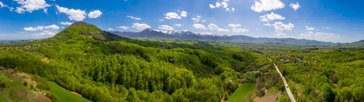 panoramic view from drone of the mountain with green hills and road in spring 