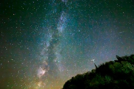 Night sky with stars and milky way over hill