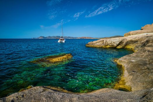 Yacht boat in Aegean sea at white rocks of Sarakiniko Beach, Milos island , Greece