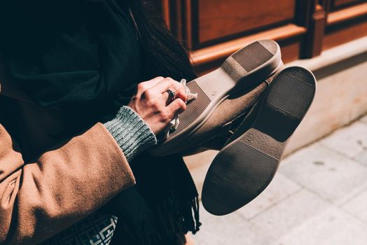 woman wipes the sole of the shoe with a damp cloth