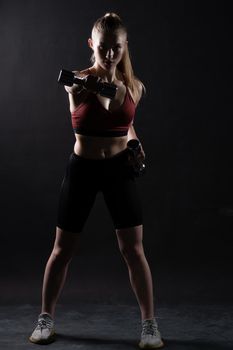 With black background beautiful dumbbells stands on a A girl Keira Knightley girl dumbbells sports body, In the afternoon health fit in sport from trainer athlete, sportswear people. Sweat model