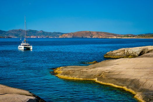 Yacht boat in Aegean sea at white rocks of Sarakiniko Beach, Milos island , Greece