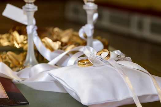 Weddings symbols, attributes. Wedding rings on the luxury white pillows. Selective focus