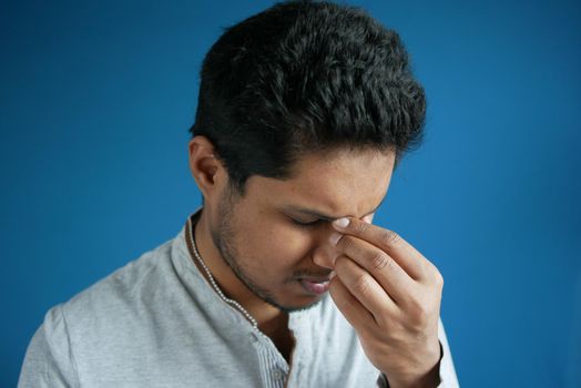 Close up of upset man suffering from strong eye pain.