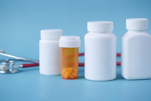 selective focus. stethoscope and pills container on wooden background