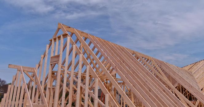 Panoramic view of wooden frame house under construction, roof truss system beams