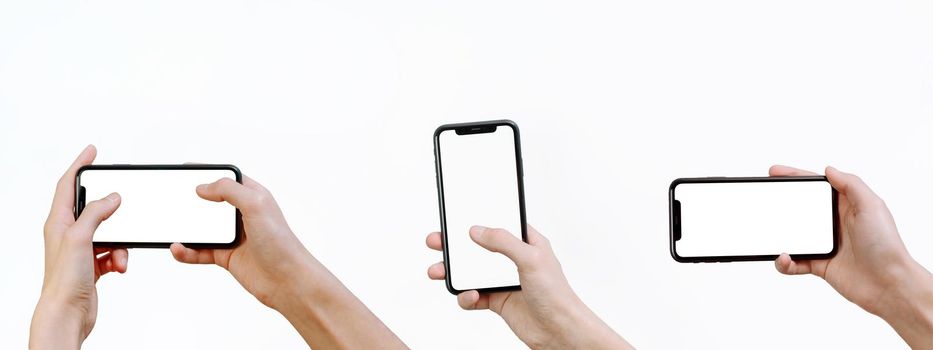 Young man holding a smartphone with a mockup on a white background. Web banner. Smartphone mock-up. Set of hands holding a modern smartphone in different positions with blank screen.