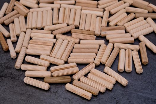 View of a grouping of wooden dowels on grey background. Close-up. Selective focus.