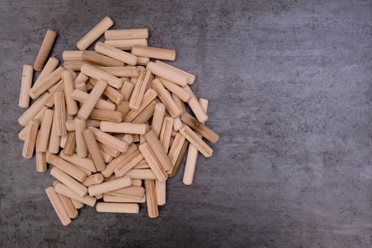 View of a grouping of wooden dowels on grey background. Close-up. Selective focus.